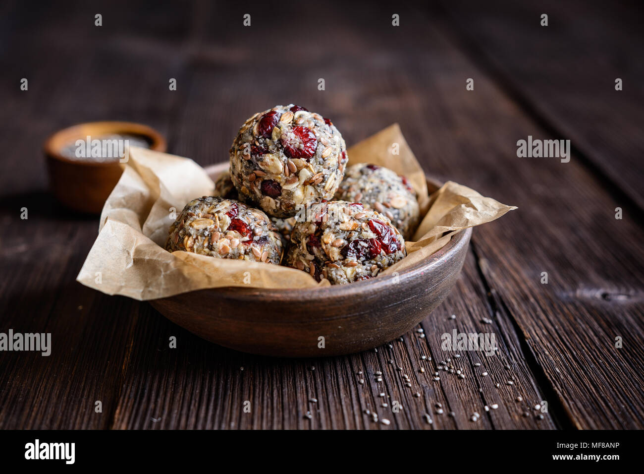 Gesunde Rohstoffe Haferflocken Kugeln mit Chia Samen, getrocknete Cranberries, Kokosraspeln, Leinsamen und Honig Stockfoto