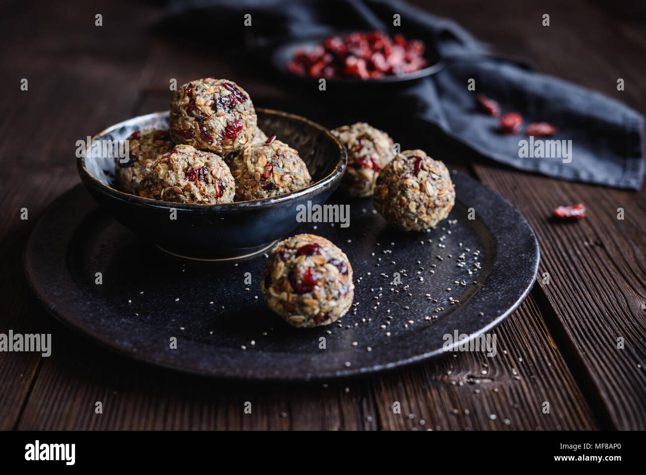 Gesunde Rohstoffe Haferflocken Kugeln mit Chia Samen, getrocknete Cranberries, Kokosraspeln, Leinsamen und Honig Stockfoto