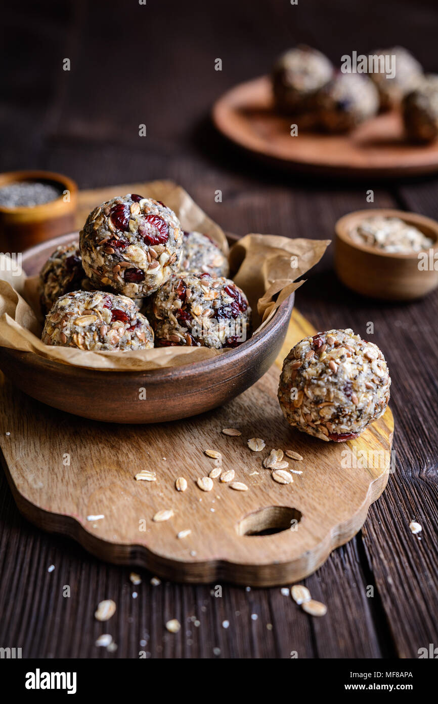 Gesunde Rohstoffe Haferflocken Kugeln mit Chia Samen, getrocknete Cranberries, Kokosraspeln, Leinsamen und Honig Stockfoto