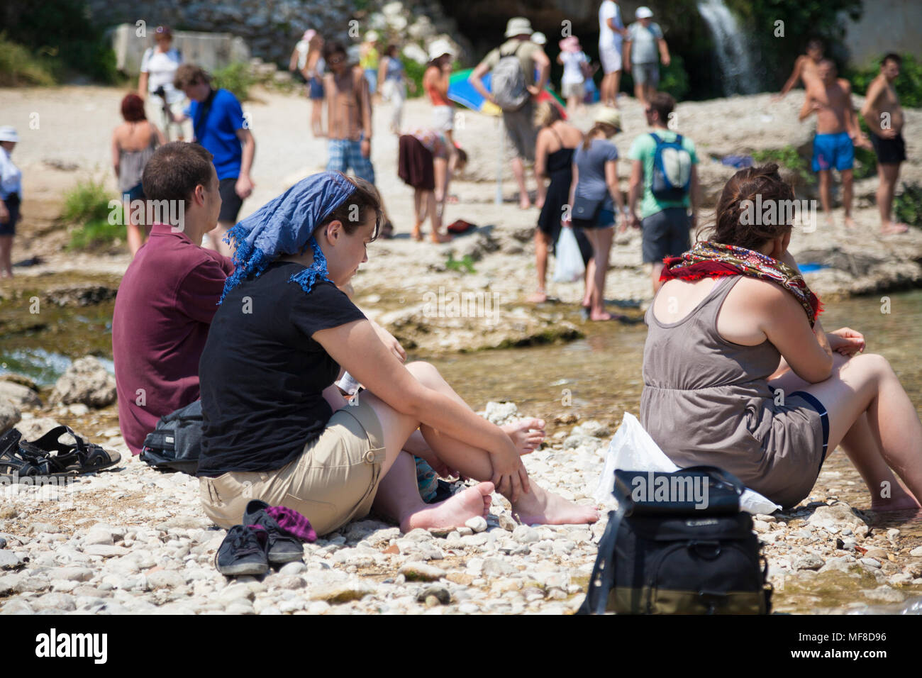 Touristen entspannen an der Seite des Flusses Neretva in der Nähe der Stari Most, der Alten Brücke in Mostar, Bosnien und Herzegowina Stockfoto