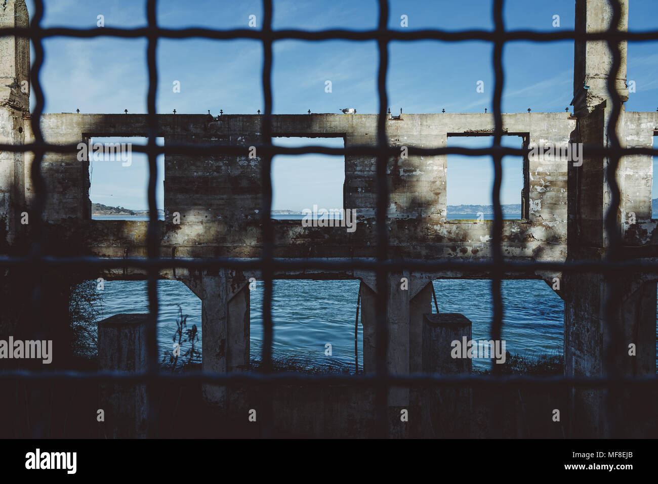 Die Ruinen von einem Gebäude auf Alcatraz Island durch ein Drahtgeflecht gesehen Stockfoto