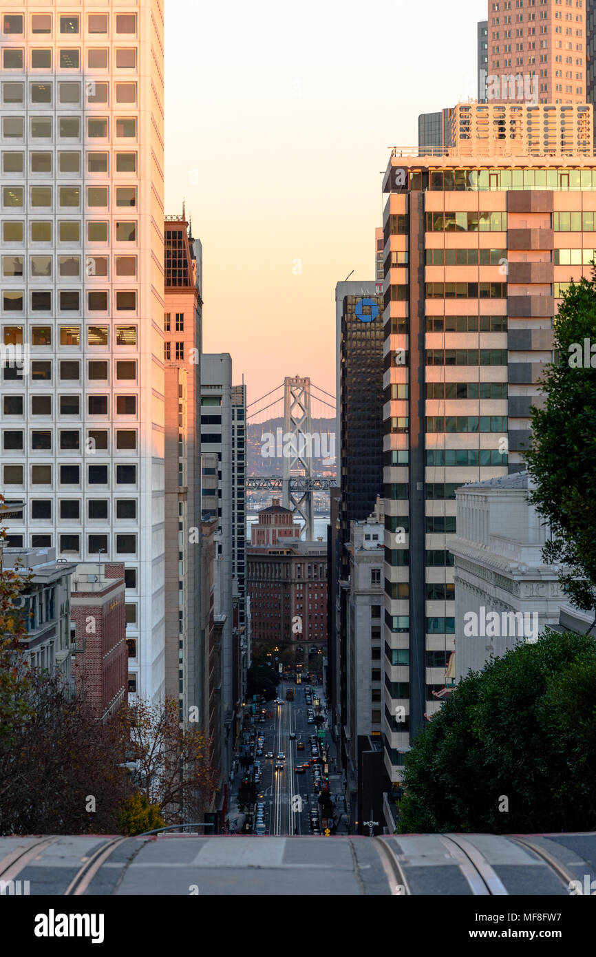Eine Säule der San Francisco Bay Bridge kann zwischen Hochhäusern auf der California Street im Golden Stunde gesehen werden. Stockfoto