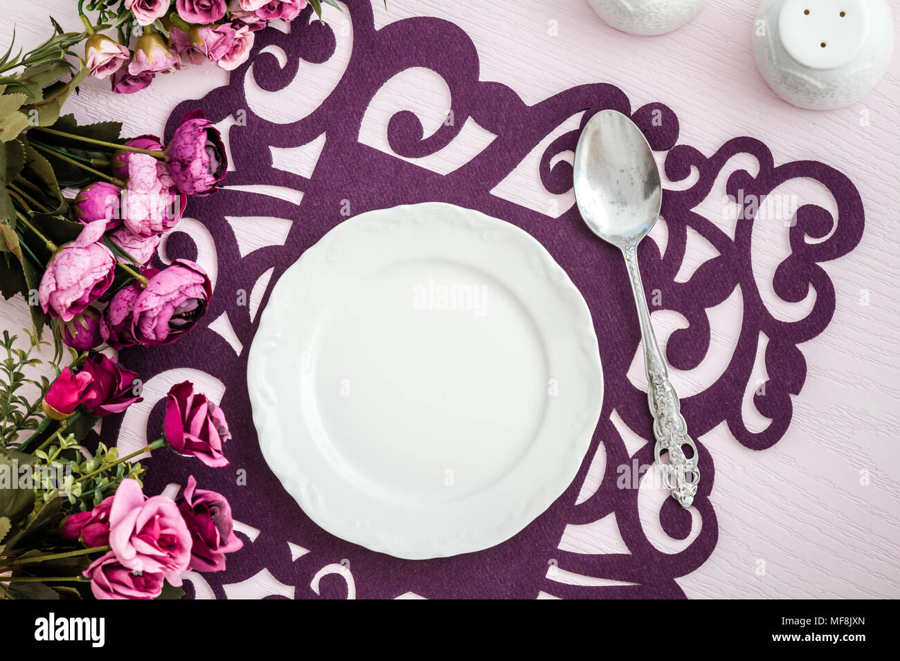 Tisch mit künstlichen Blumen und bunten Läufer aus Filz, Stoff Stockfoto