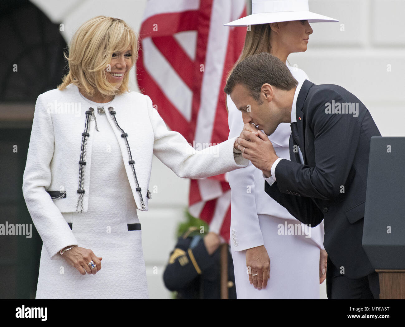 Washington, District of Columbia, USA. 24 Apr, 2018. Präsident Emmanuel längestrich von Frankreich küsse die Hand seiner Frau, Brigitte Längestrich, nach Abschluss der Begrüßungszeremonie auf dem Rasen des Weißen Hauses in Washington, DC am Dienstag, 24. April 2018. First Lady Melania Trump ist dargestellt hinter ihnen. Credit: Ron Sachs/CNP Credit: Ron Sachs/CNP/ZUMA Draht/Alamy leben Nachrichten Stockfoto