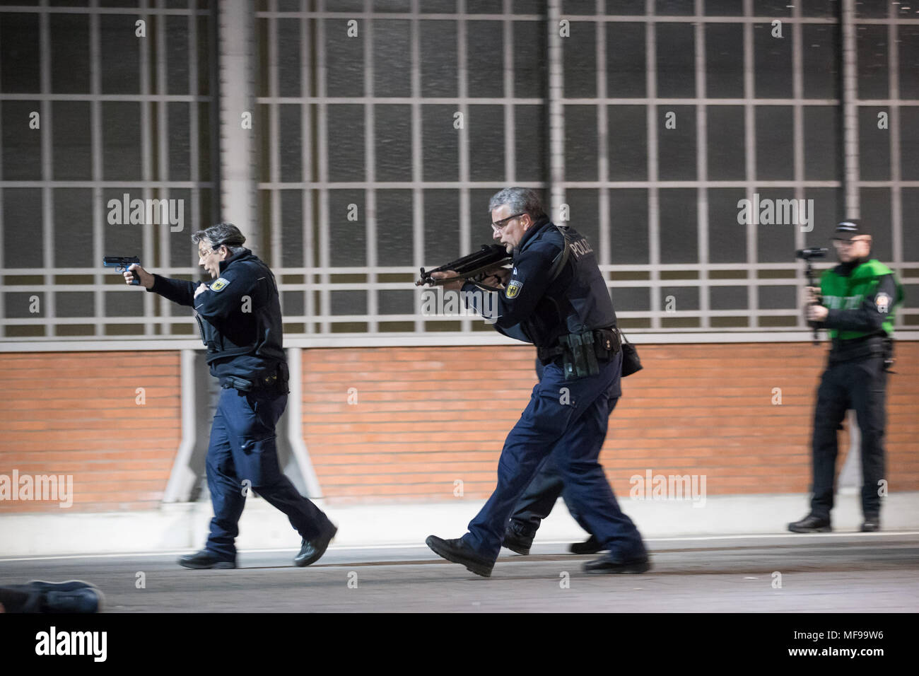 24 April 2018, Deutschland, Lübeck: Polizisten und Passanten über eine Plattform laufen während einer Demonstration für eine Anti-Terror-Übung in Lübeck entfernt. Fast 700 Polizisten von Staat und Land sowie über 120 Einsatzkräfte der Feuerwehr und Notfalldienste beteiligen sich an dieser Übung am Hauptbahnhof. Foto: Christian Charisius/dpa Stockfoto