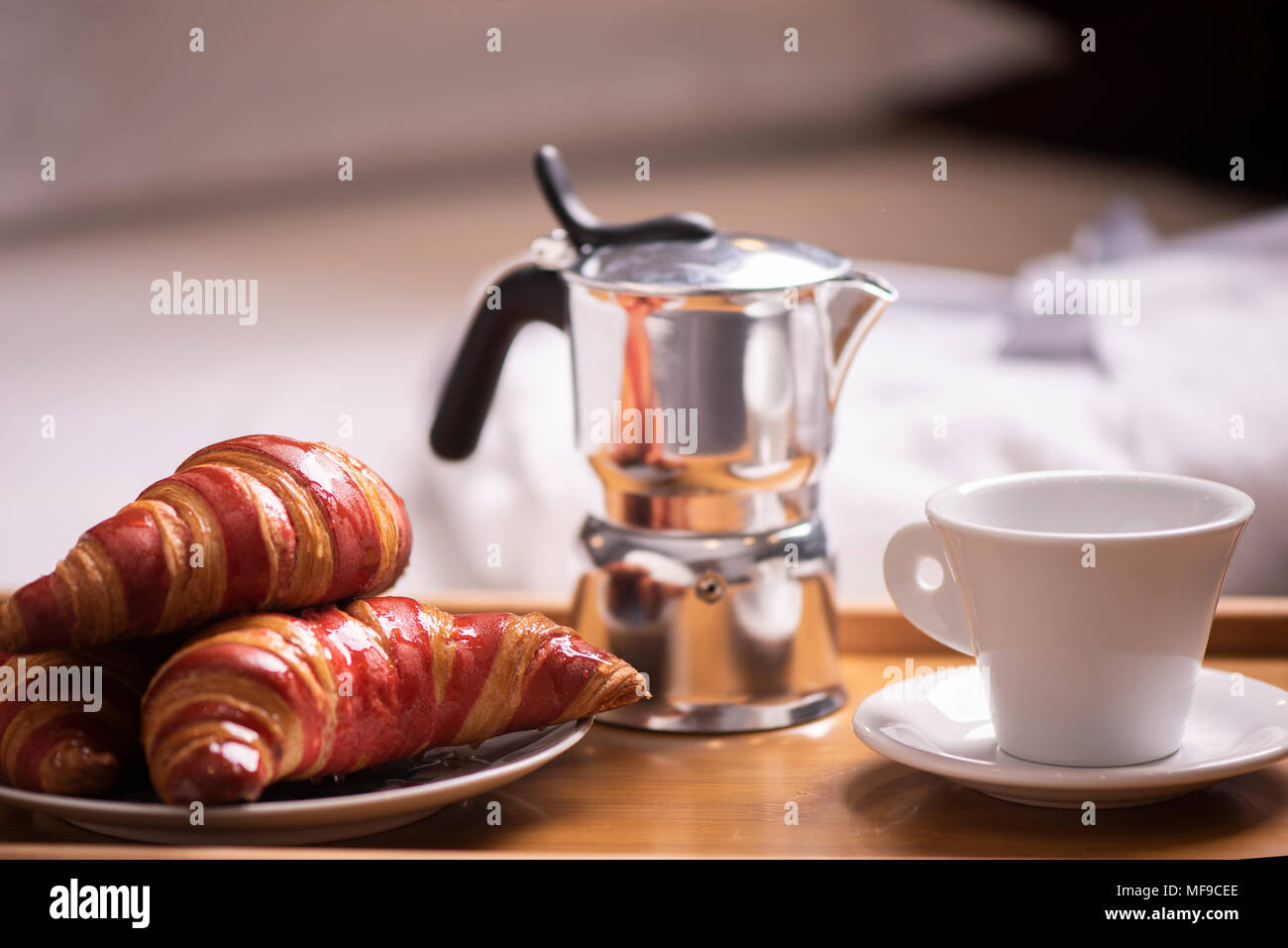Frühstück im Bett. Tablett mit Kaffee und Croissants. Stockfoto