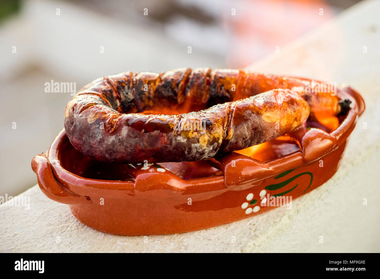 Traditionelle portugiesische chourico oder spanischer Chorizo in einem speziellen Tontopf auf Alkohol vorbereitet Stockfoto