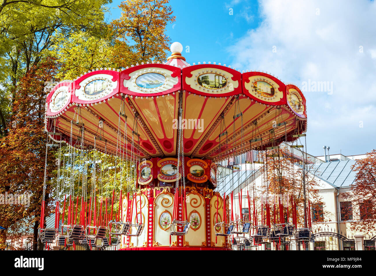 Leere Karussell Merry-Go-Round mit Sitzen ausgesetzt auf Ketten ohne Menschen warten auf Ihre Besucher. Attraktionen im Herbst, Schließen der Umgebung Stockfoto