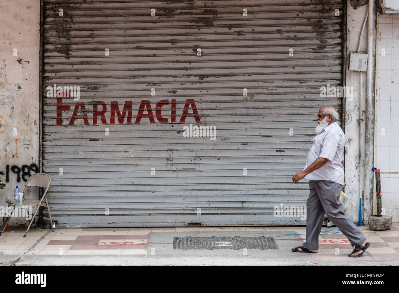 Panama City, Panama - März 2018: alte Person auf dem Bürgersteig vor der Apotheke auf der belebten Einkaufsstraße in Panama City, Avenida Central Stockfoto