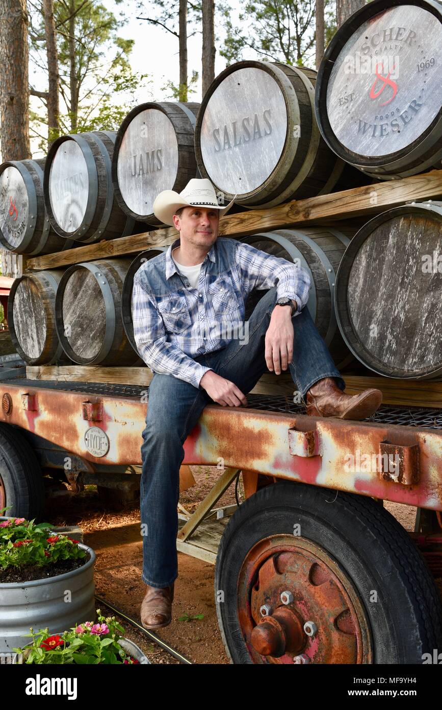 Western Cowboy auf Tieflader mit Whisky Fässern oder Fässer im Das Peach Haus, Fredericksburg, Texas, USA sitzen. Stockfoto