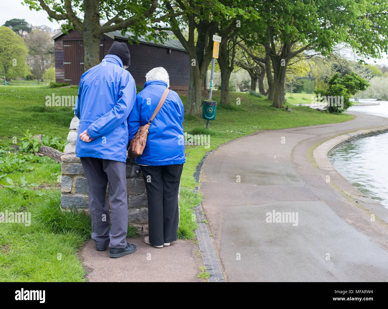 April 2018 - älteres Ehepaar das Auschecken eines Information Board in einem öffentlichen Park. Stockfoto