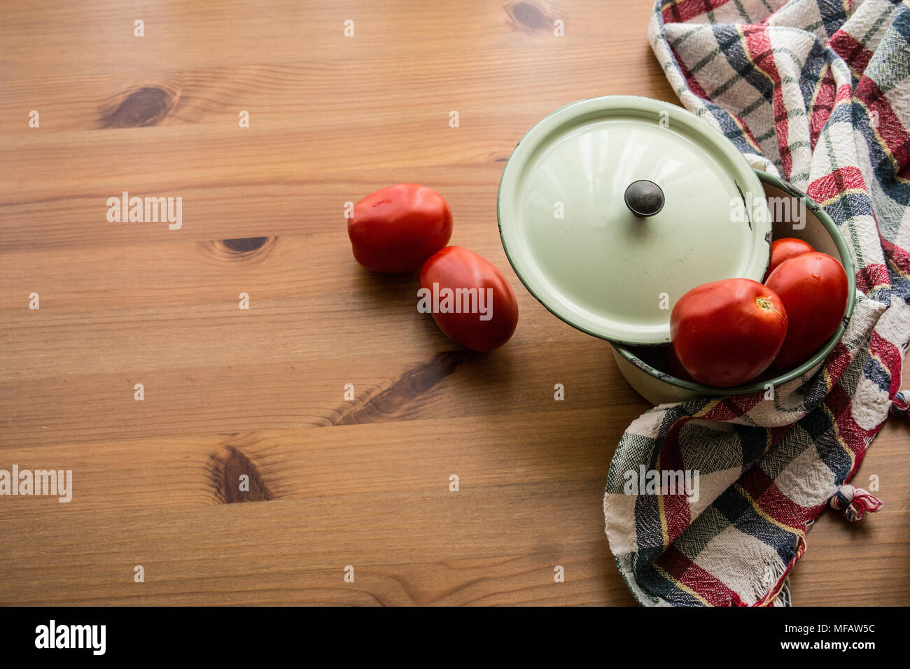 Tomaten mit Topf auf einem Holz- Oberfläche und eine rustikal Tischdecke. (Konzept Hintergrund.) Stockfoto