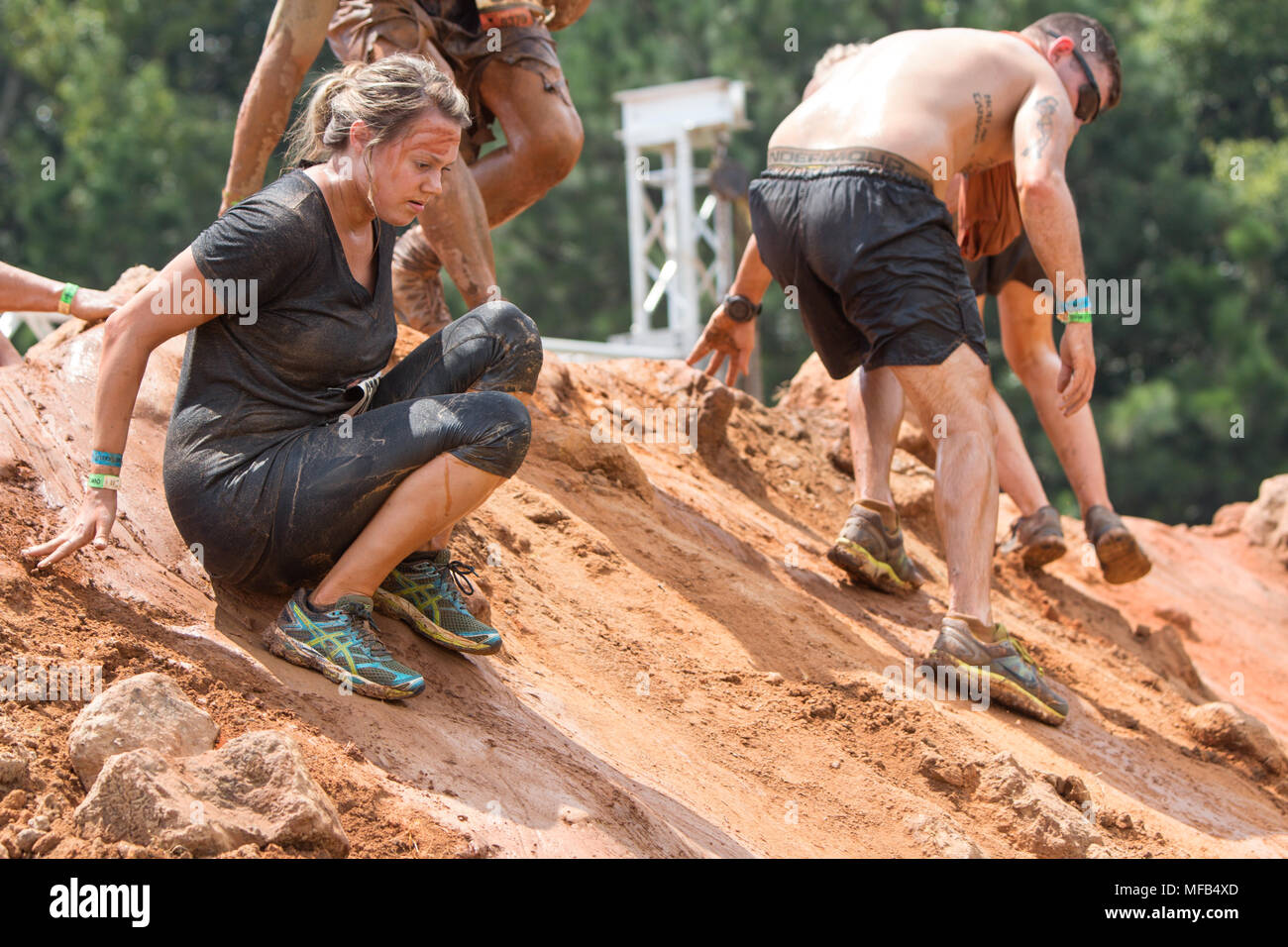 Wettbewerber aufmerksam machen sich auf den Weg nach unten eine große glitschige Erdhügel an der robusten Maniac Hindernisparcours Rennen am 22. August 2015 in Atlanta, GA. Stockfoto