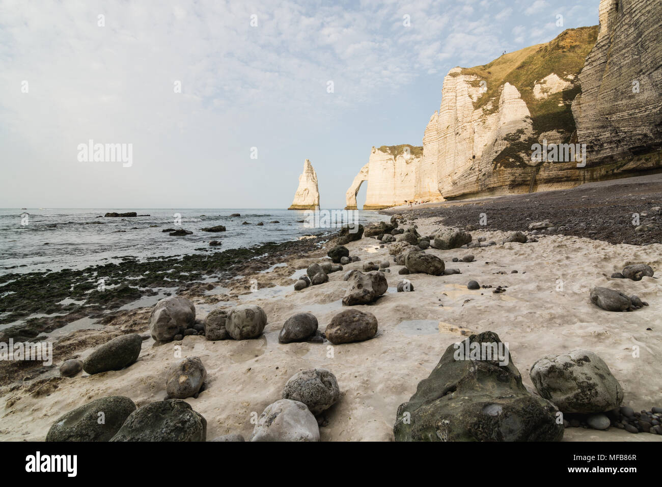 Steiniger Strand bei Ebbe vor L'Aiguille oder die Nadel rock und Porte d'Aval bei Etretat, Normandie, Frankreich Stockfoto