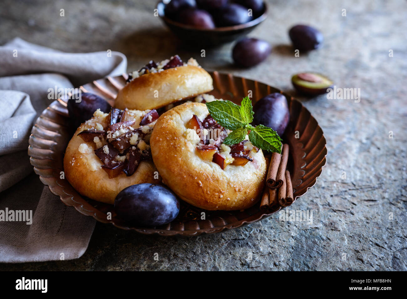 Leckere Obstkuchen mit in Scheiben geschnittenen Pflaumen, Zimt und Streusel topping Stockfoto