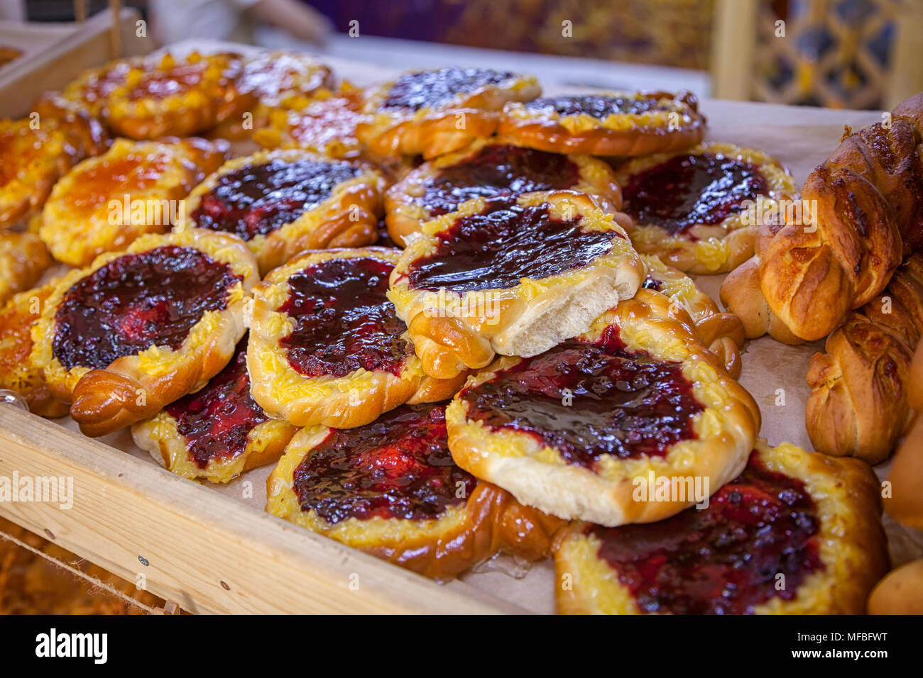 Nahaufnahme der frische und köstliche Brötchen mit einer Beere, Cowberry in einem Schaukasten in einer Bäckerei Stockfoto