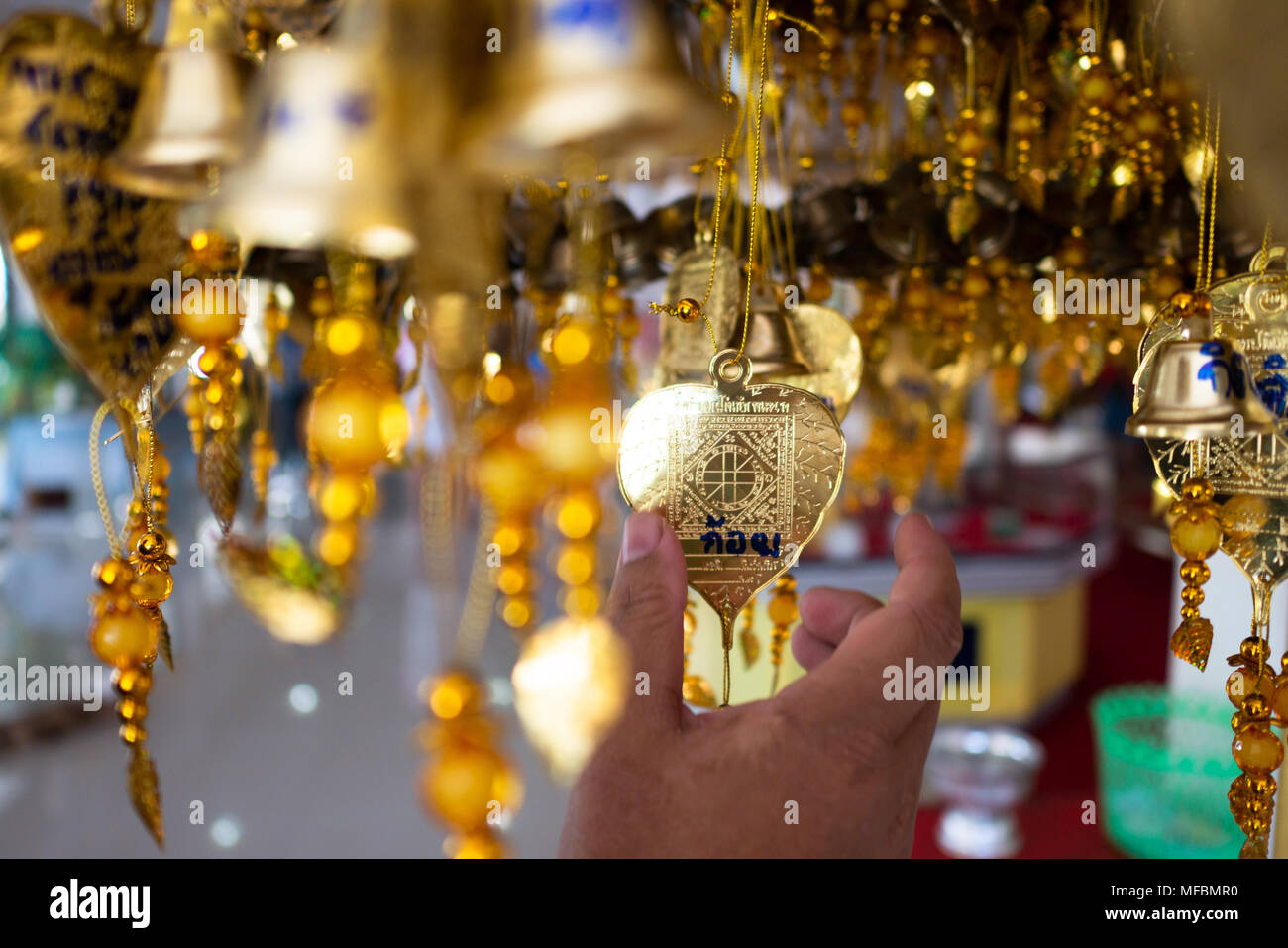 Man Hände sind in Pho Thong. Thai Überzeugungen festgehalten, wenn auf den Buchstaben Pho geschrieben, glücklich sein wird. Pho, Pho silber gold, Thai Tempel, wählen Sie Fokus Flach Stockfoto