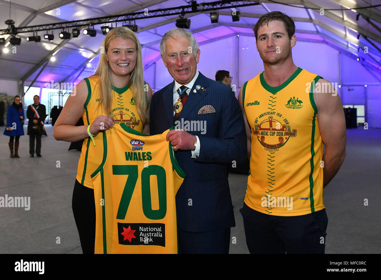 Der Prinz von Wales ist mit einem Anzac Cup AFL Jersey durch die Australische Geist Frauen Kapitän Priscilla Lodge (links) und Männern den Kapitän Edward Morgan (rechts) afteran am frühen Morgen Denkmal an der Villers-Bretonneux Memorial in Frankreich, das 100-jährige Jubiläum der Schlacht von Amiens zu markieren. Stockfoto