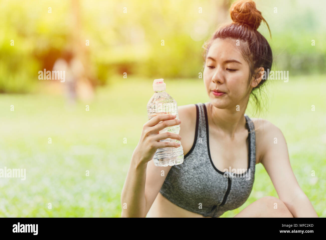 Asiatische sport jugendlich Blick auf Trinkwasser Flasche während der Aktivität im Freien selektiven Fokus am Wasser trinken Flasche Stockfoto