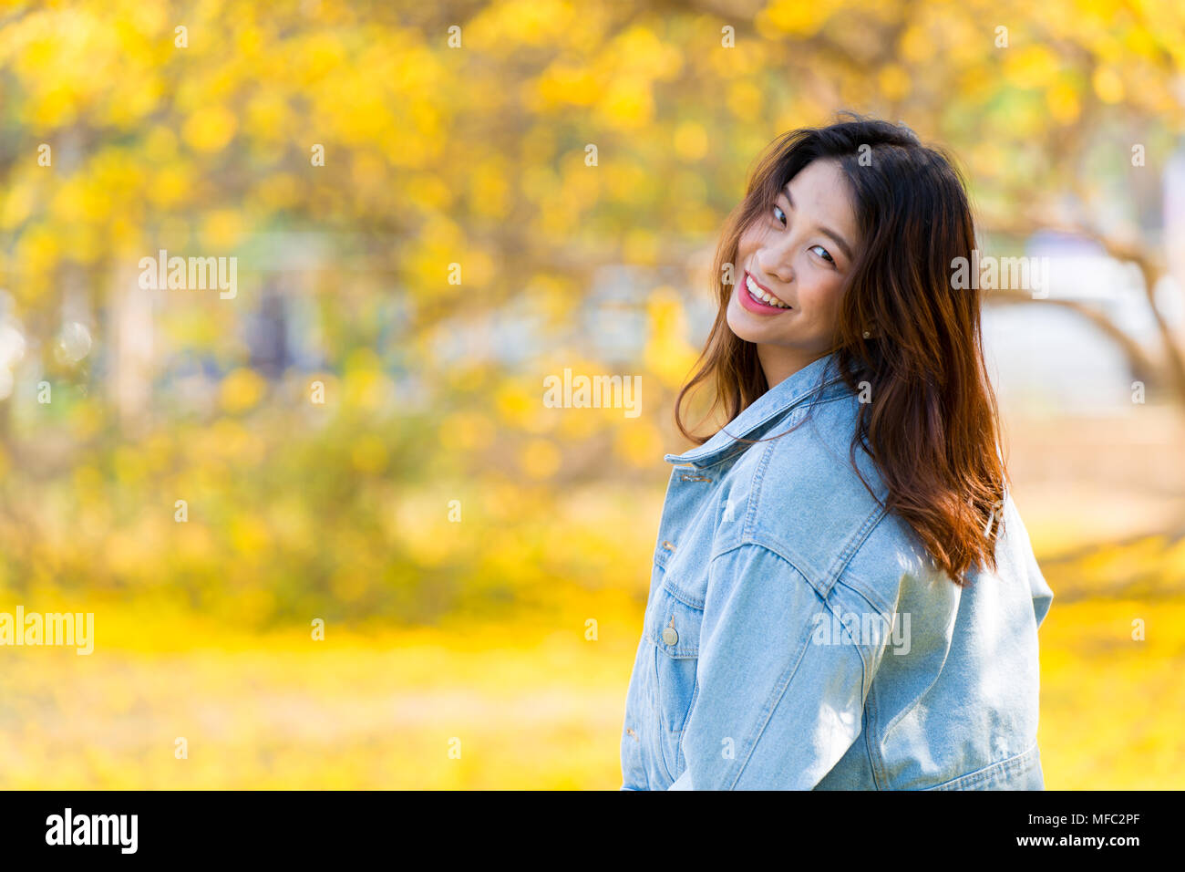 Süße asiatische Frauen nette junge Teen Lächeln glücklich mit gelbe Blume blur Hintergrund und Platz für Text Stockfoto
