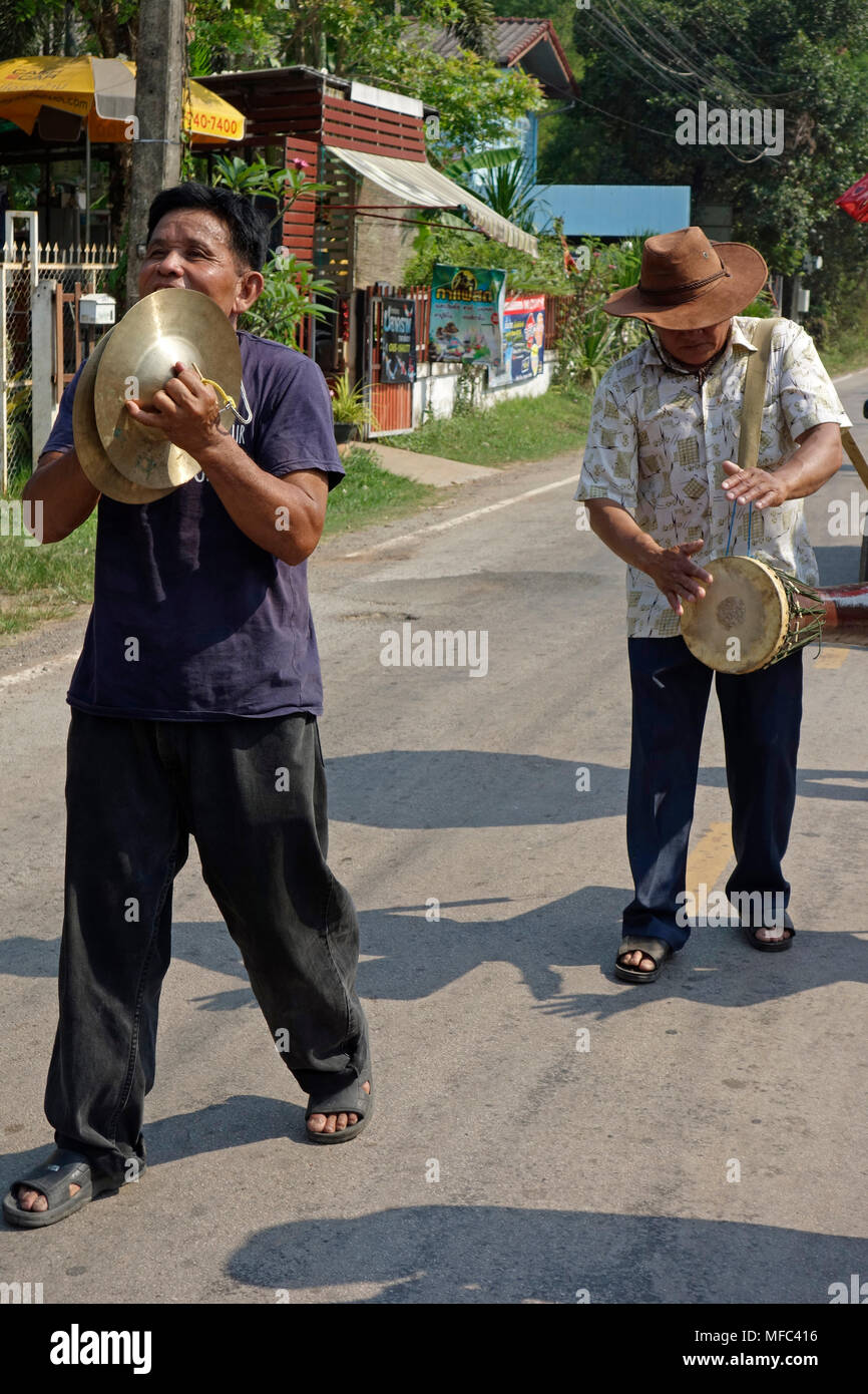 Straßenmusikanten spielen Zimbeln und Becher am Kopf einer Parade in einem ländlichen Dorf Straße Trommel auf songkran Tag 2018, Thai Neujahr, Udon Thani, Thailand Stockfoto