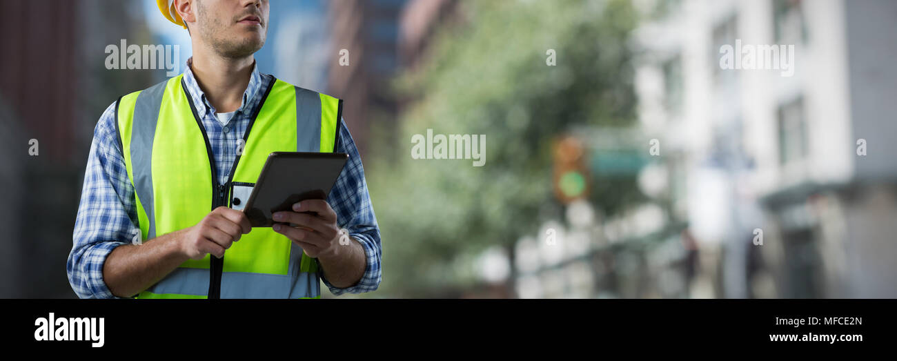 Das zusammengesetzte Bild von konzentriertem Bauarbeiter mit Tablet Stockfoto