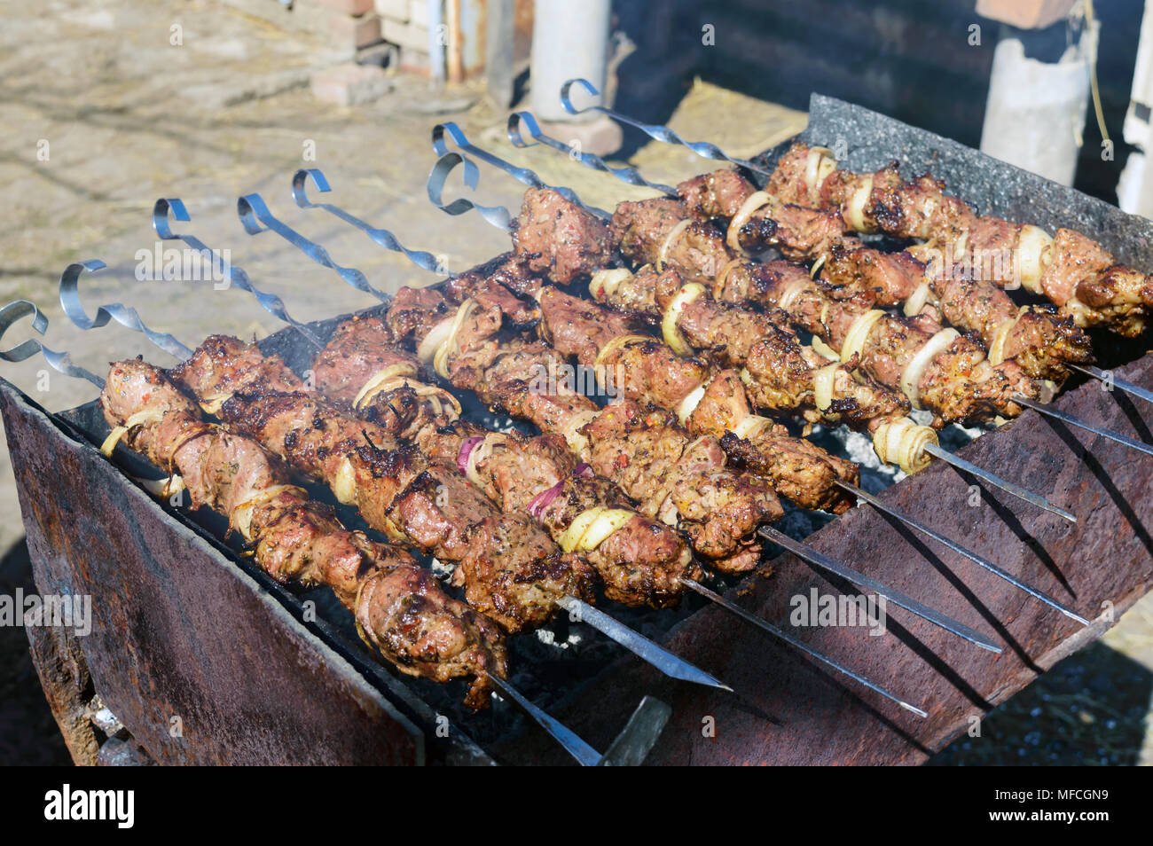 Fleisch auf Eisen Spieße, auf offenem Feuer gekocht. Shish Kebab geröstet im Freien. Picknick. Stockfoto