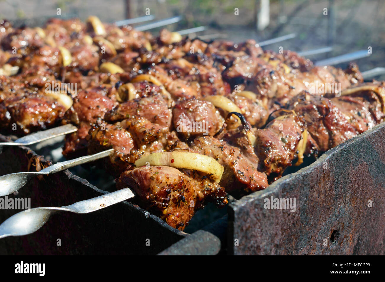 Fleisch auf Eisen Spieße, auf offenem Feuer gekocht. Shish Kebab geröstet im Freien. Picknick. Stockfoto