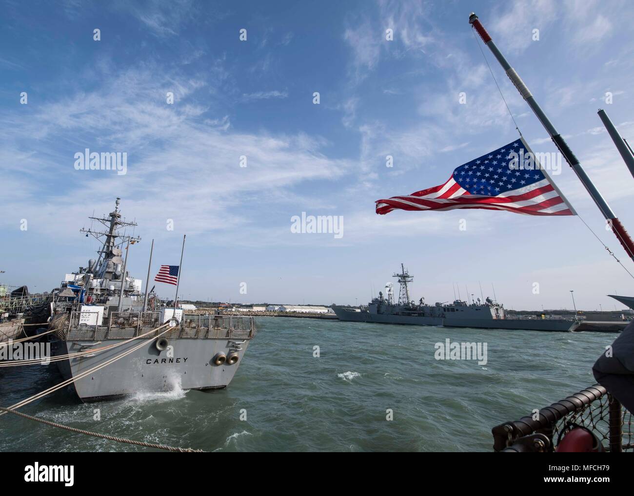 180420-N-IC 246-1131 NAVAL STATION Rota, Spanien (20. April 2018) Die fähnriche der geführt - Flugzerstörer USS Arleigh Burke (DDG51) und USS Carney (DDG64) fliegen auf Halbmast ehemalige First Lady Barbara Bush zu ehren. Arleigh Burke ist derzeit als Teil der Harry S. Truman Carrier Strike Group bereitgestellt. Mit dem Flugzeugträger USS Harry S. Truman (CVN 75) als Flaggschiff, die Bereitstellung von strike Group unterstützt gehören Personal, Schiffe und Flugzeuge von Carrier Strike Group (CSG) 8, Destroyer Squadron (DESRON) 28 und Carrier Air Wing (Cvw) 1; sowie die Sachsen-Klasse deutsche Fregatte FGS Hessen (F221). ( Stockfoto