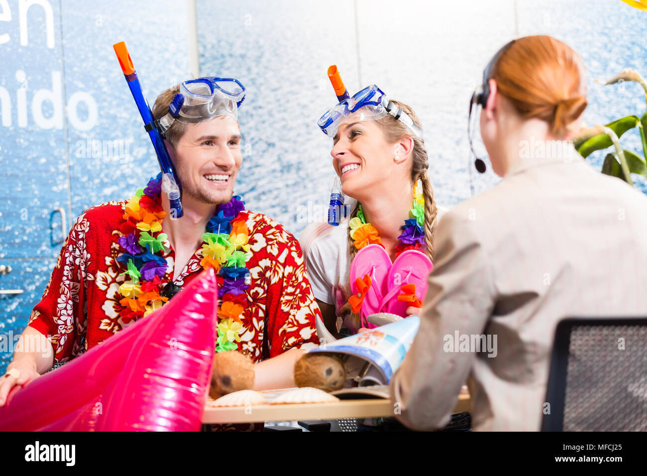 Mann und Frau buchen Urlaub am Strand Stockfoto