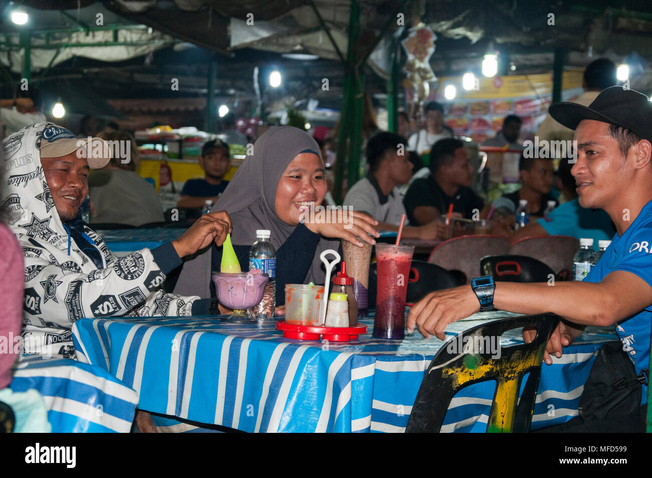 Malaysische Familie Gruppe heraus speisen auf dem Nachtmarkt an der Waterfront Kota Kinabalu, Sabah, Malaysia Borneo Stockfoto