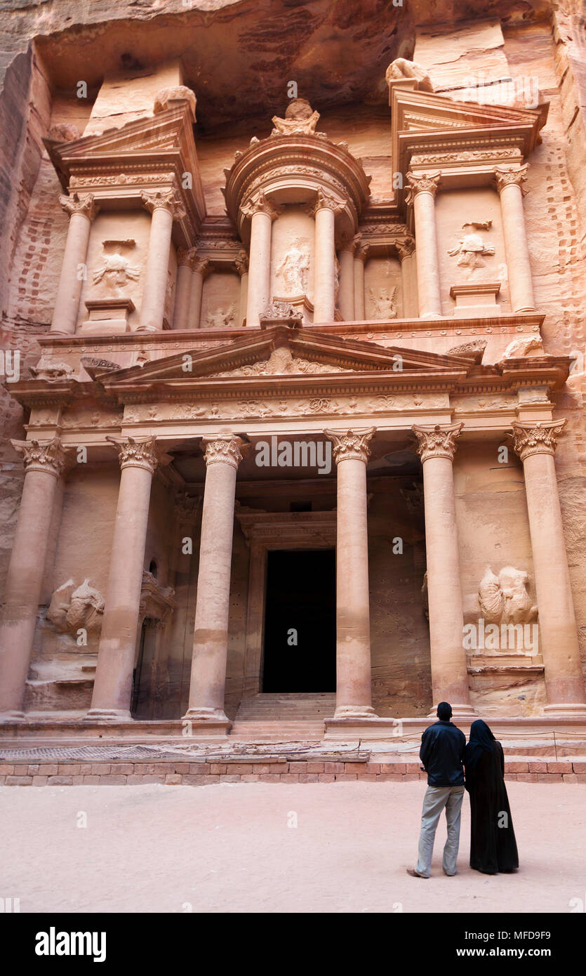 Arabische paar Suchen im Tempel in den Felsen von El Hazne, der Hauptstadt des Nabatäischen Reiches, Petra, Jordanien geschnitzt Stockfoto
