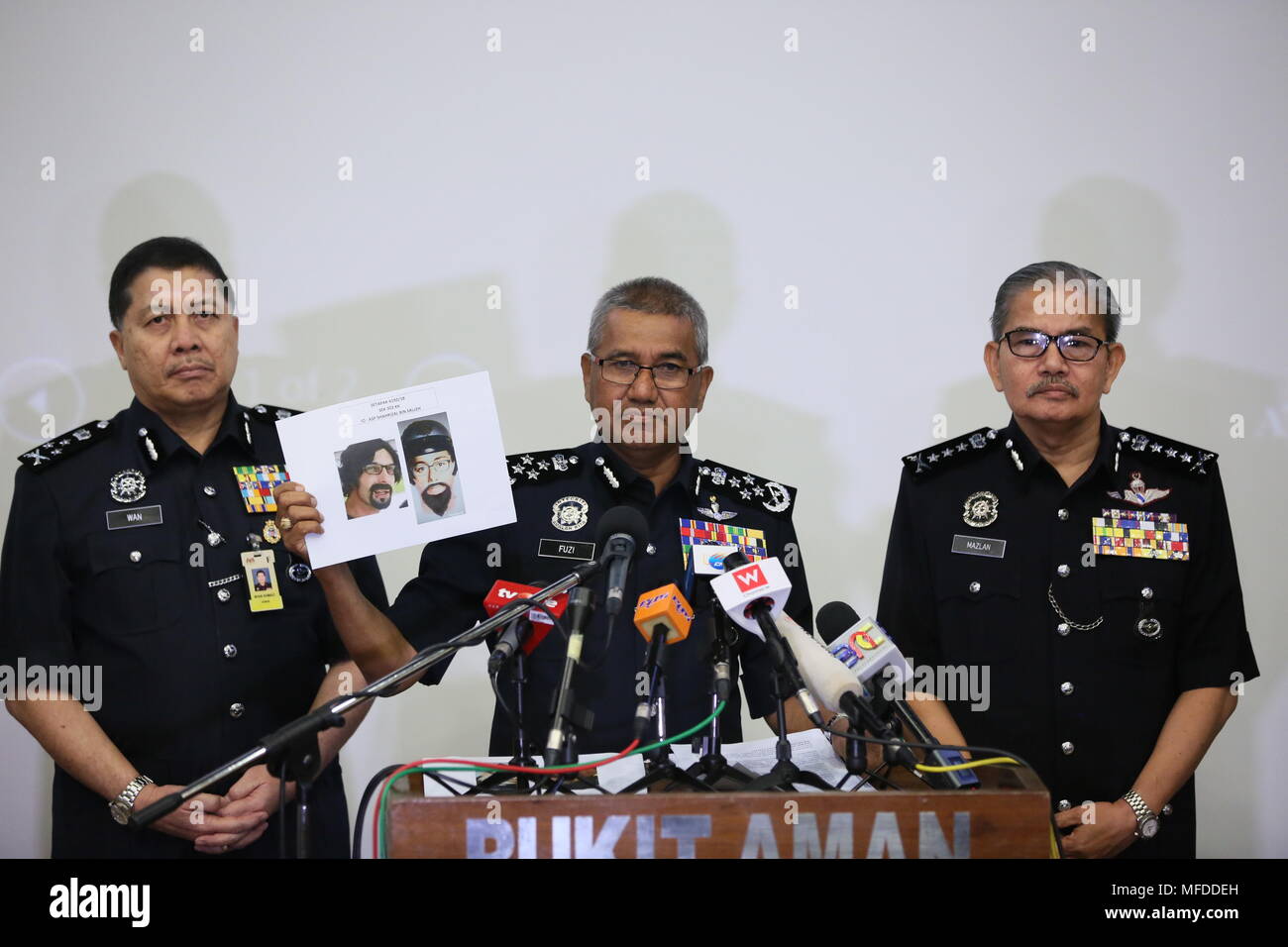 Kuala Lumpur, Malaysia. 25 Apr, 2018. Malaysische Polizei chief Mohamad Aconit Bin Harun (C) zeigt ein Foto von einer der beiden Verdächtigen, die einen palästinensischen Dozenten getötet, während einer Pressekonferenz in Kuala Lumpur, Malaysia, am 25. April 2018. Malaysische Polizei am Mittwoch freigegeben ein frisches Foto von einer der beiden Verdächtigen, die einen palästinensischen Dozenten getötet, und bat um öffentliche Unterstützung, um die Verdächtigen zu glauben noch immer im Land zu finden. Credit: Zhu Wei/Xinhua/Alamy leben Nachrichten Stockfoto