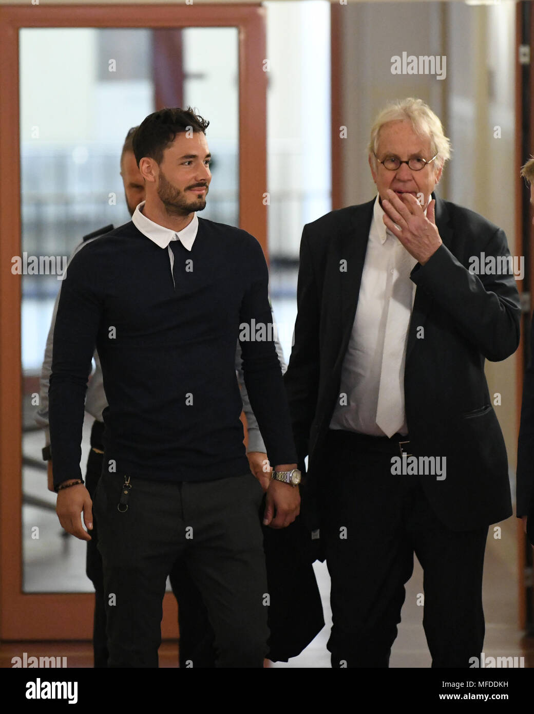 25 April 2018, Deutschland, Dortmund: Der BVB professionelle Römische Buerki und sein Rechtsanwalt Alfons Becker zu Fuß in Richtung der Gerichtssaal des Amtsgerichts. Das Landgericht bezeichnet, wenn der Player als Zeuge im Prozess um den Angriff auf die Mannschaft von Borussia Dortmund. Alle Spieler waren im Team Bus, wenn drei Sprengsätze im April 2017 brannte. Foto: Ina Faßbender/dpa Stockfoto