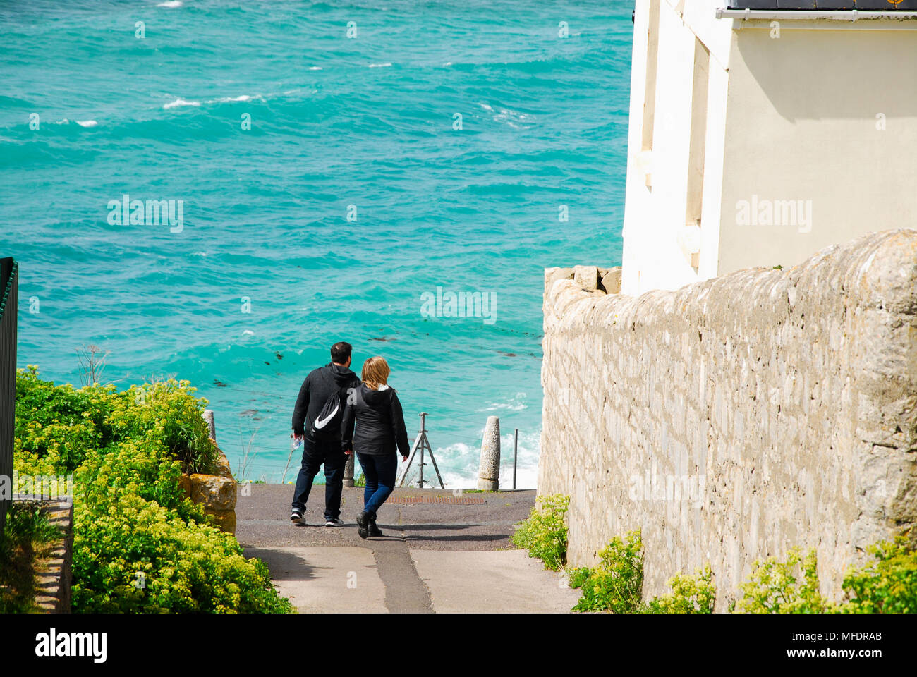 Portland. 25. April 2018. UK Wetter: Ein paar Kopf unten einen steilen Pfad das azurblaue Wasser der Chesil Beach, Portland Kredit zu sehen: stuart Hartmut Ost/Alamy leben Nachrichten Stockfoto