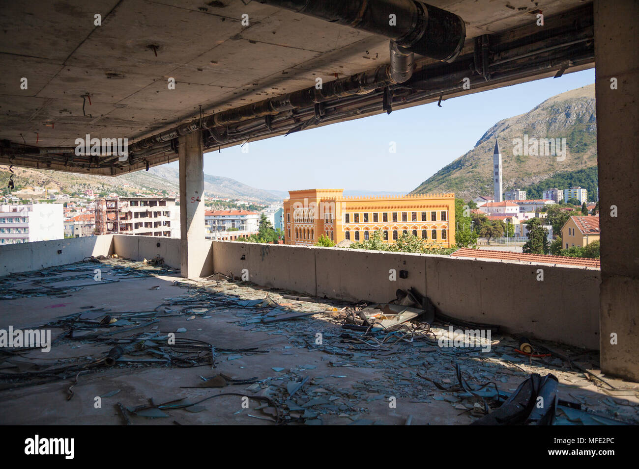 Blick auf den United World College von einem zerbombten Gebäude aus dem Bosnischen Krieg in Mostar, Bosnien und Herzegowina Stockfoto