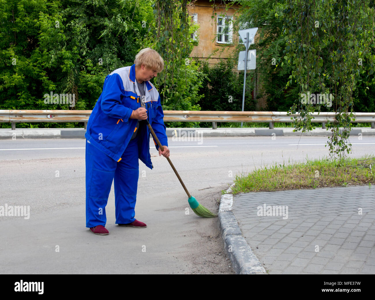 Voronezh, Russland - 14. Juni 2017: eine Frau Hausmeister fegt die Straße Stockfoto