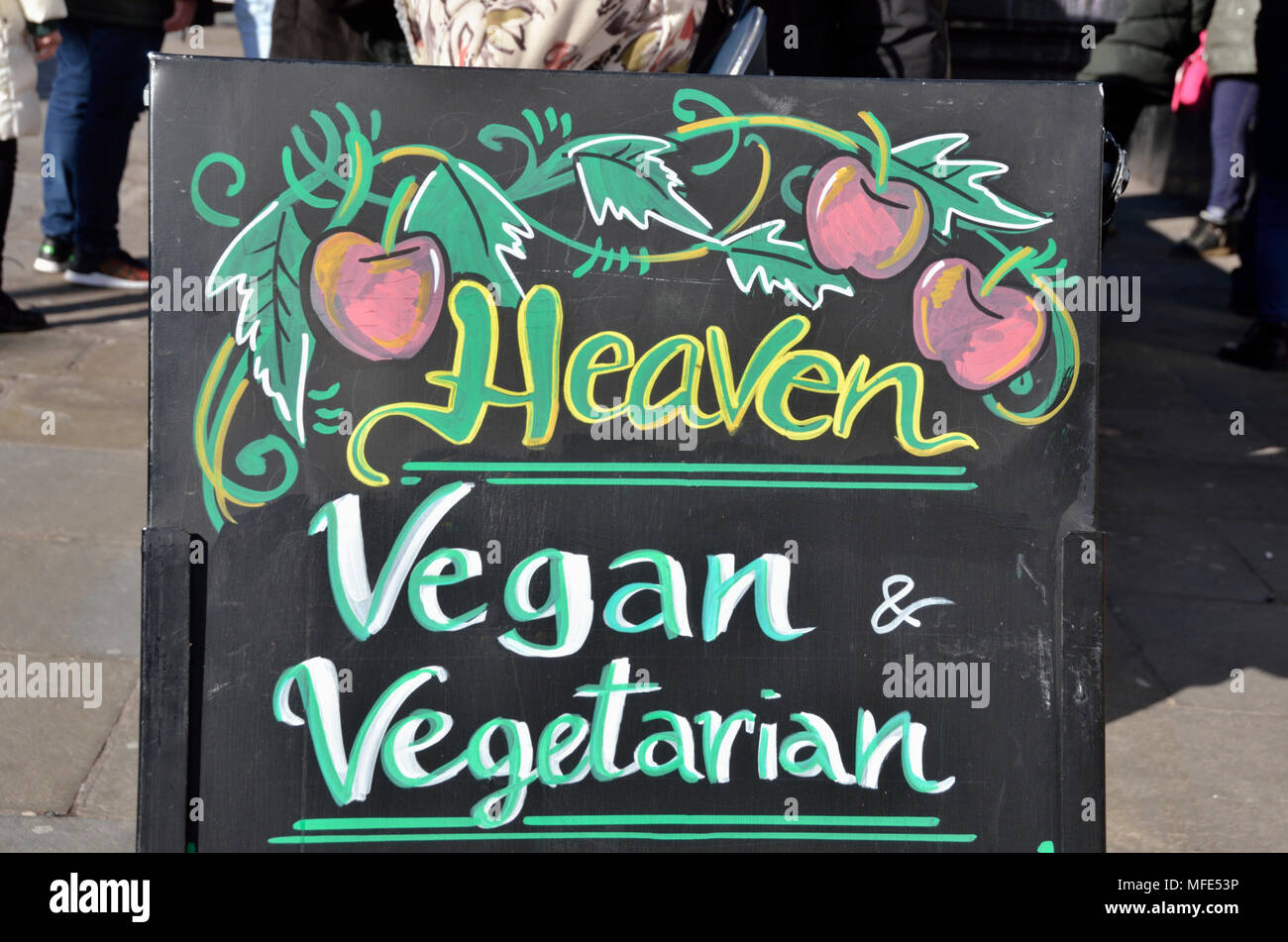 Ein Brett außerhalb einer veganen und vegetarischen Restaurant. Stockfoto