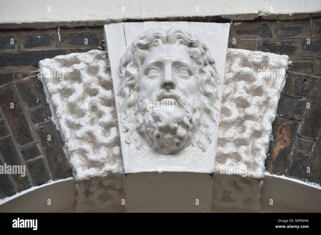 Reich verzierten Stein schnitzen eines menschlichen Kopfes über einer Tür Bogen in Bedford Square, Bloomsbury, London, UK. Stockfoto