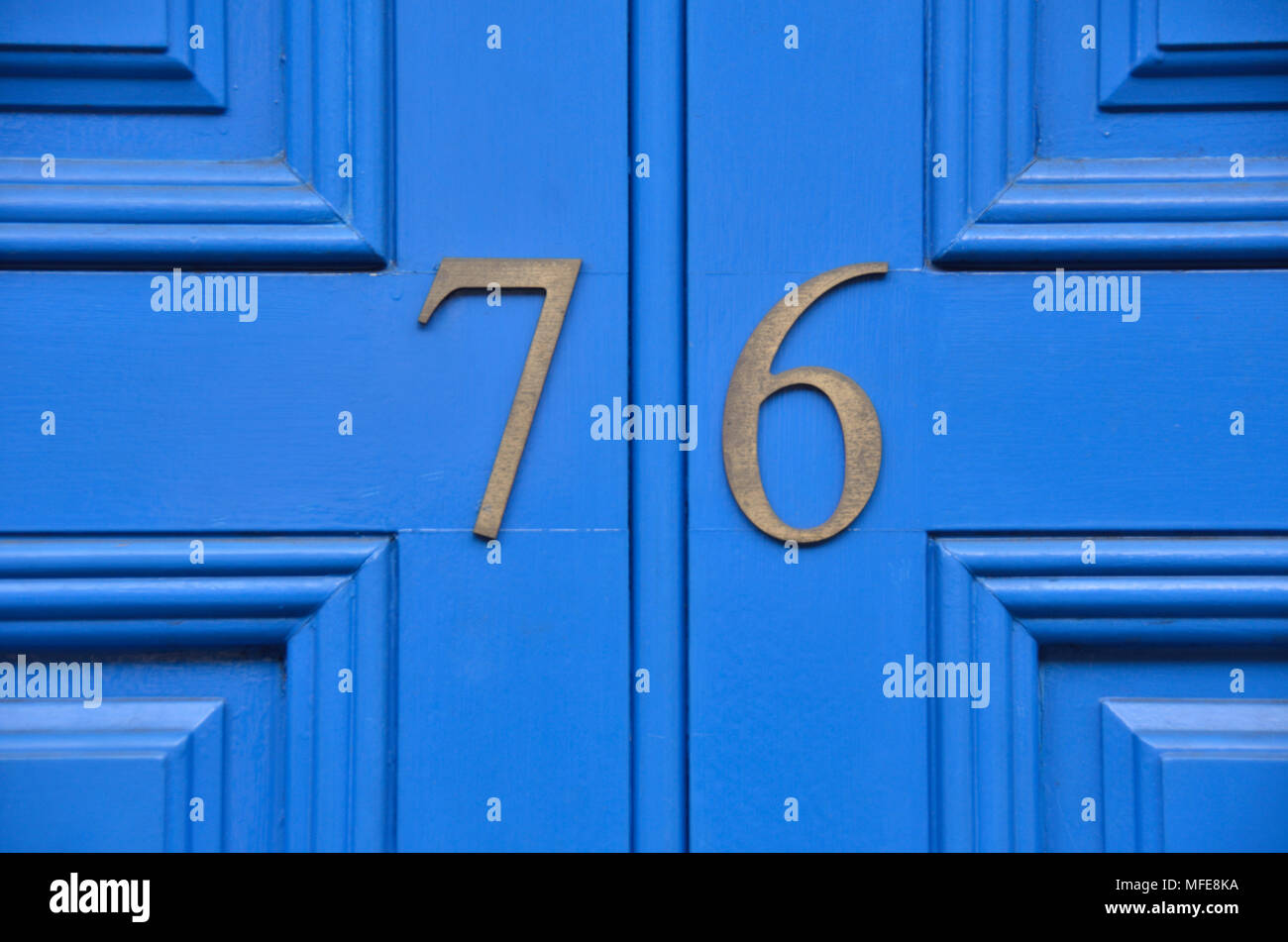 Straße Nummer 76 76 auf einem blauen Haus Tür. Stockfoto