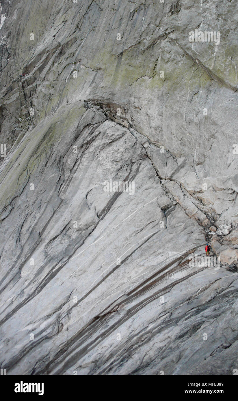 Blick auf die klassischen Nordosten Gesicht des Pizzo Badile und seinen vielen Kletterrouten mit einem Kletterer Annäherung an der berühmten Via Cassin Stockfoto