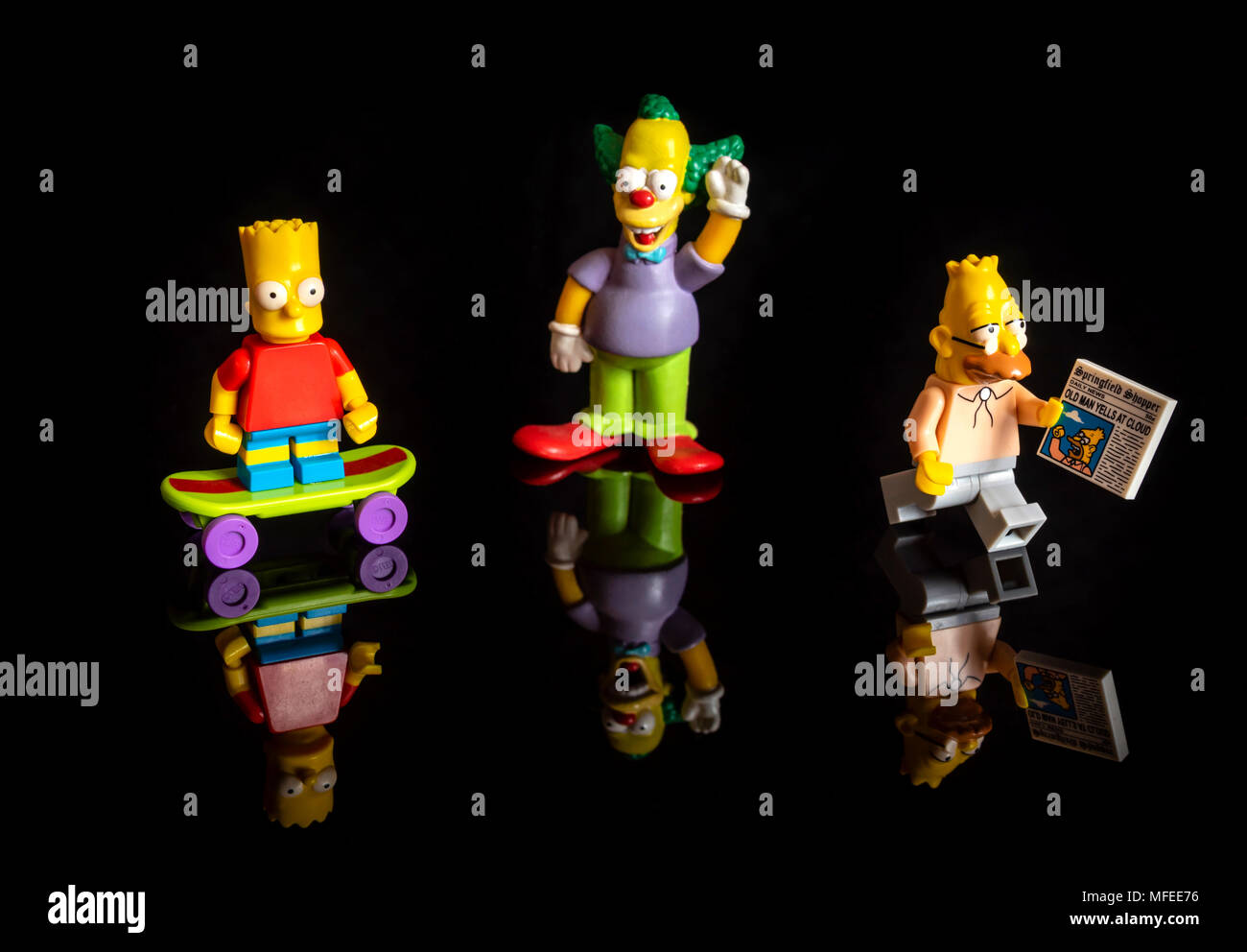 Die Simpsons Lego miniatur Figuren (Bart Simpson, Krusty der Clown und Grampa Simpson) auf reflektierenden schwarzen Hintergrund Stockfoto