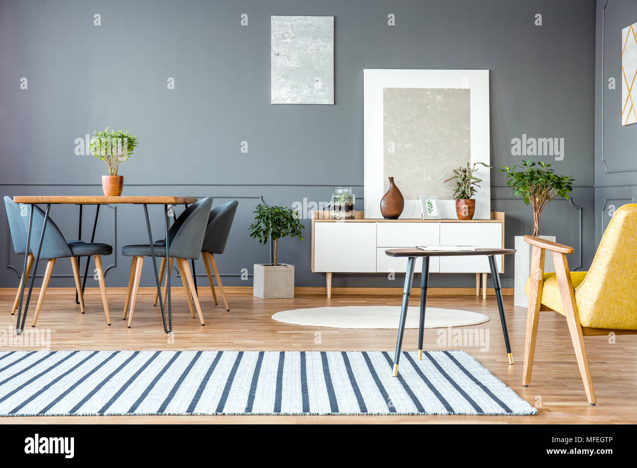 Gestreiften Teppich In Geraumigen Grau Flachbild Interieur Mit Stuhle Am Esstisch Und Gemalde Auf Graue Wand Stockfotografie Alamy