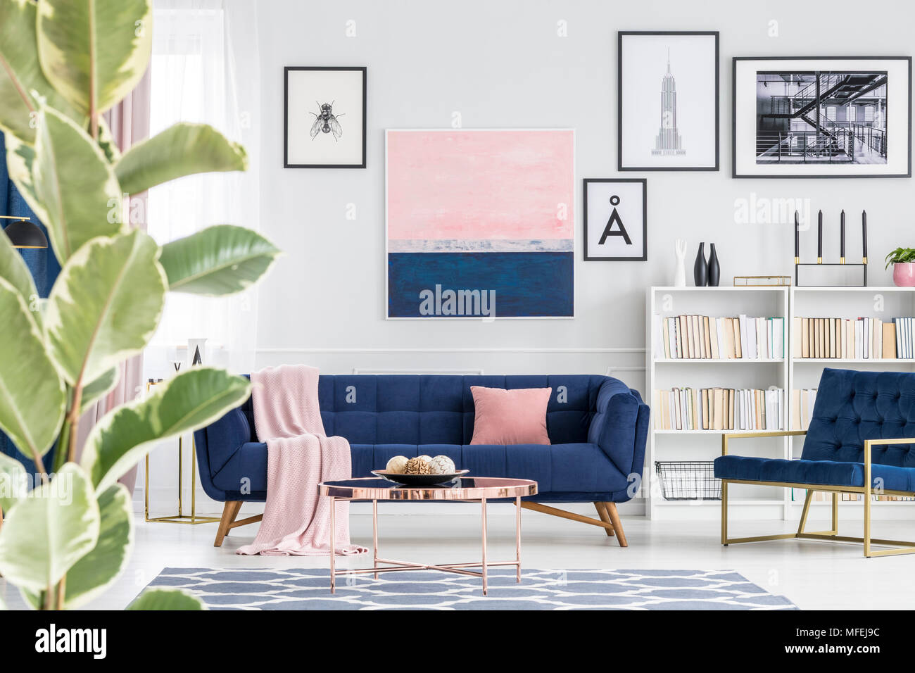 In der Nähe der Anlage im Wohnzimmer Innenraum mit blauen Couch, Sessel und Gemälden an der Wand Stockfoto