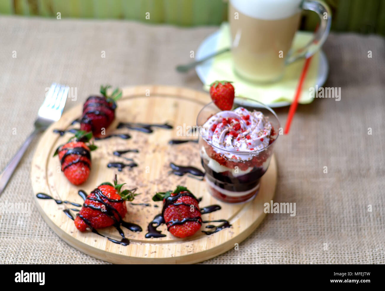 Sweet englischer Trifle Dessert mit Heidelbeere Sahne, Erdbeeren und gkass Kaffee Latte auf eine Leinwand Hintergrund. Ansicht von Oben. Stockfoto