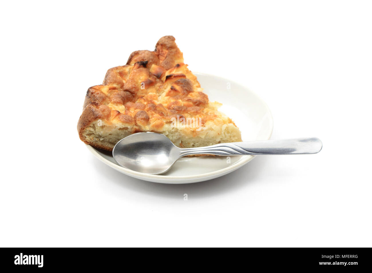 Stück Kuchen und Löffel liegen auf soucer auf weißem Hintergrund Stockfoto