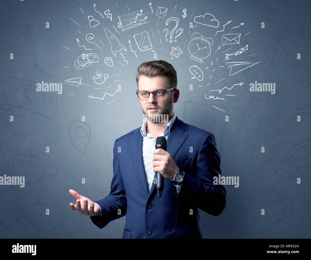 Geschäftsmann sprechen in das Mikrofon mit gemischten Doodles über seinem Kopf Stockfoto