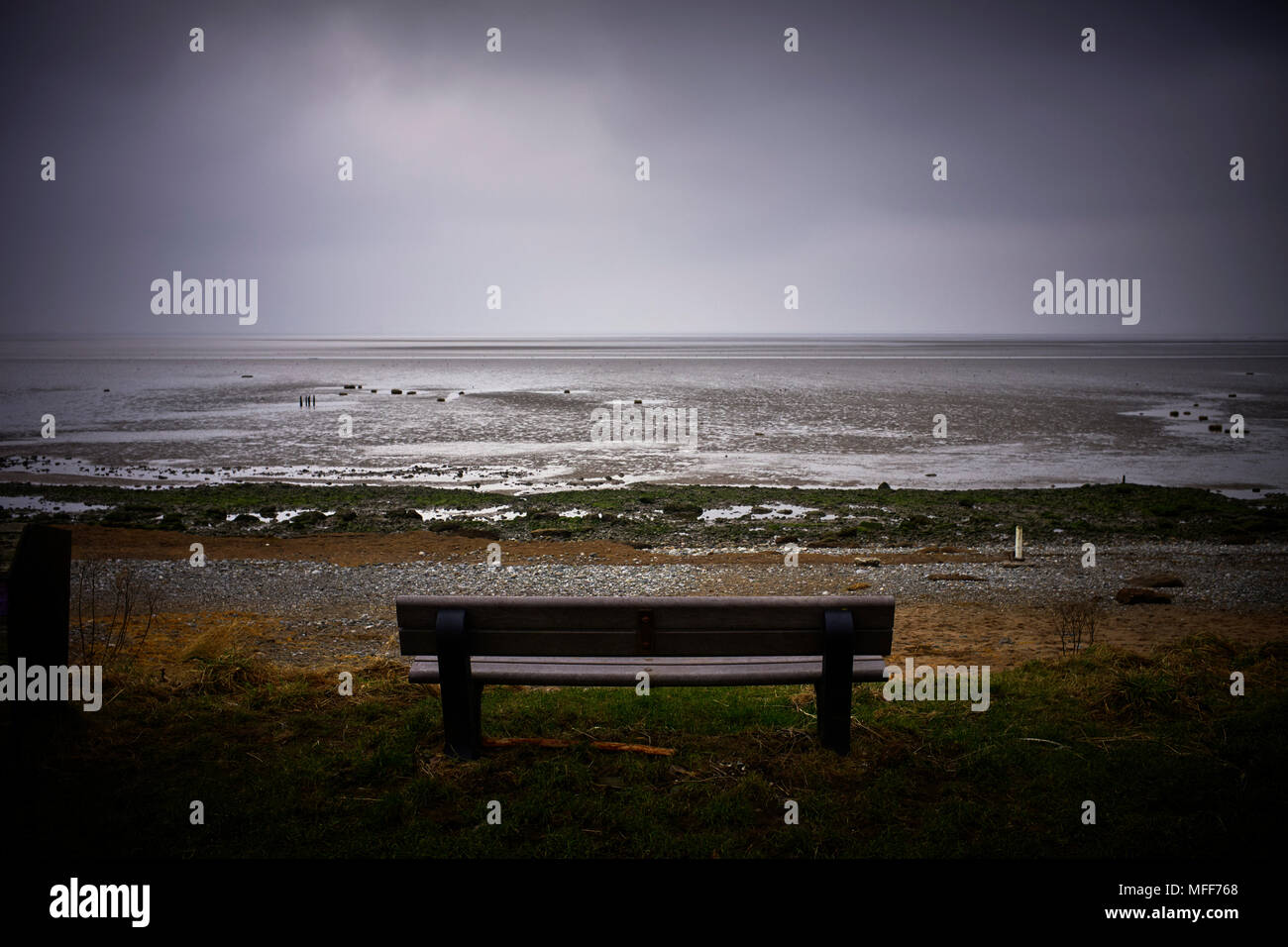 Sitz mit Blick auf Ebbe von Morecambe Bay an einem kalten Wintertag Stockfoto