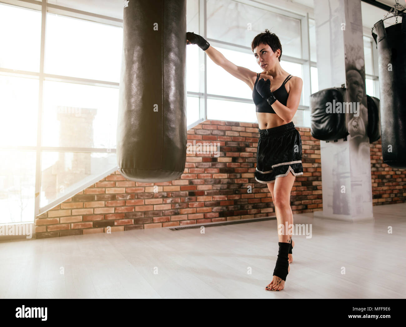 In voller Länge Porträt der passende Frau lernen Muay Thai Boxen und stehen auf Zehenspitzen an Gym. Meister der Boxing Sport Stockfoto