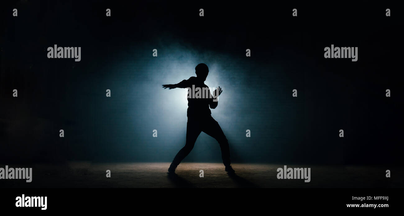 Junger Mann in casual Textilien seinen Tanz auf die dunkle Straße. Nacht zeigen. Nacht tanzen. dansing darstellen Stockfoto